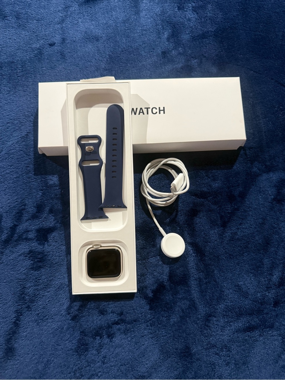 Apple Smartwatch with Navy Blue Sport Band and White Charger Cable